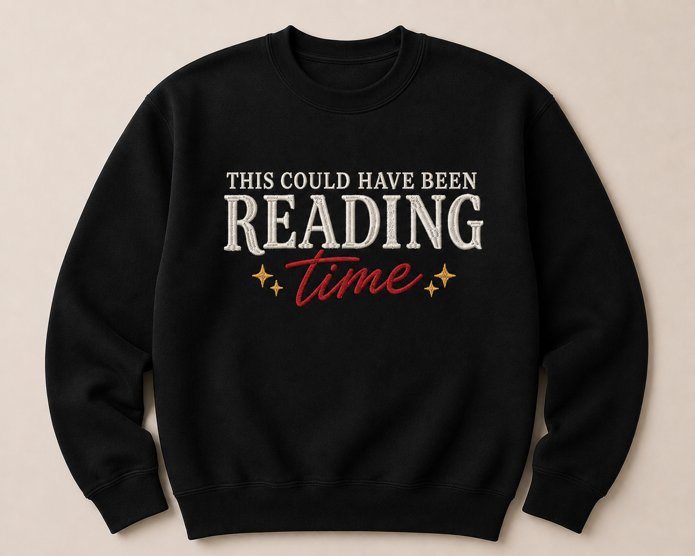 A black crewneck sweatshirt with a graphic text design reading 'THIS COULD HAVE BEEN READING time' in white and red, with small gold stars, displayed on a light beige background.